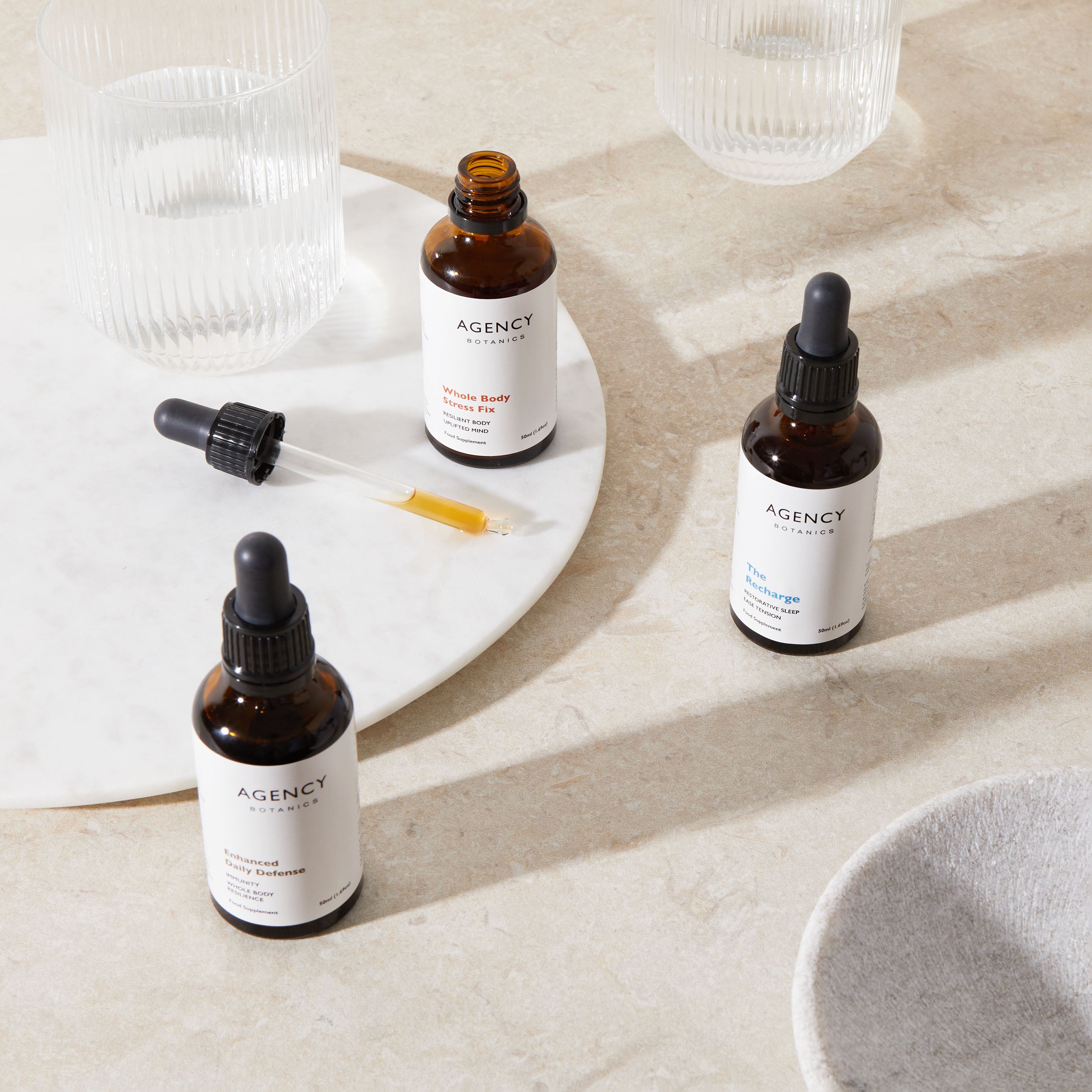 Assortment of organic herbal tinctures and supplements from Agency Botanics for immune support and energy, that are made with adaptogens including Ashwagandha, Siberian Ginseng, Schisandra, Cordyceps, Reishi, Astragalus, and elderberry.