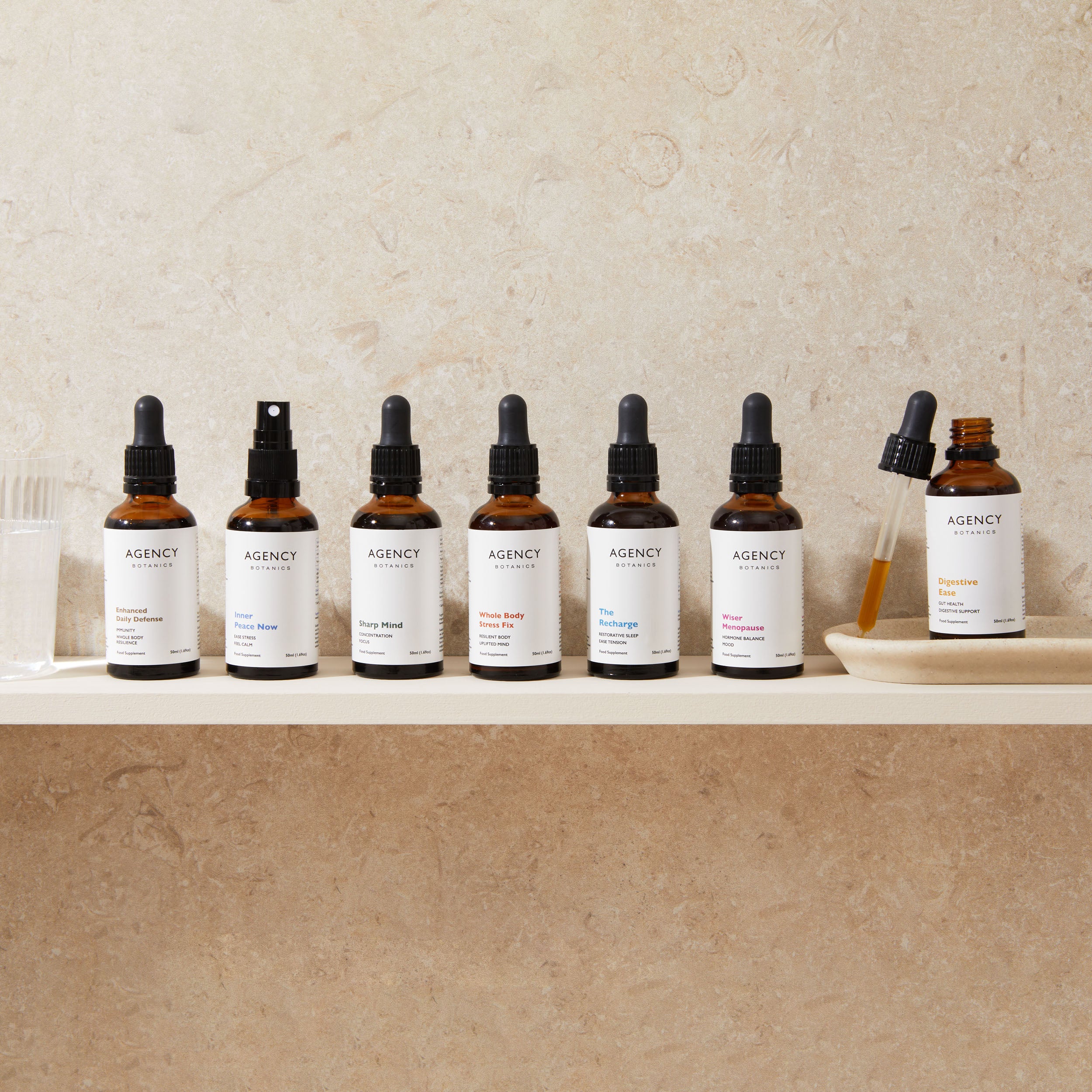 Assortment of organic herbal tinctures and supplements from Agency Botanics for stress (adaptogens), gut health (oregon grape root), immunity (astragalus), menopause (vitex), brain health (Lion's Mane), sleep (passionflower).