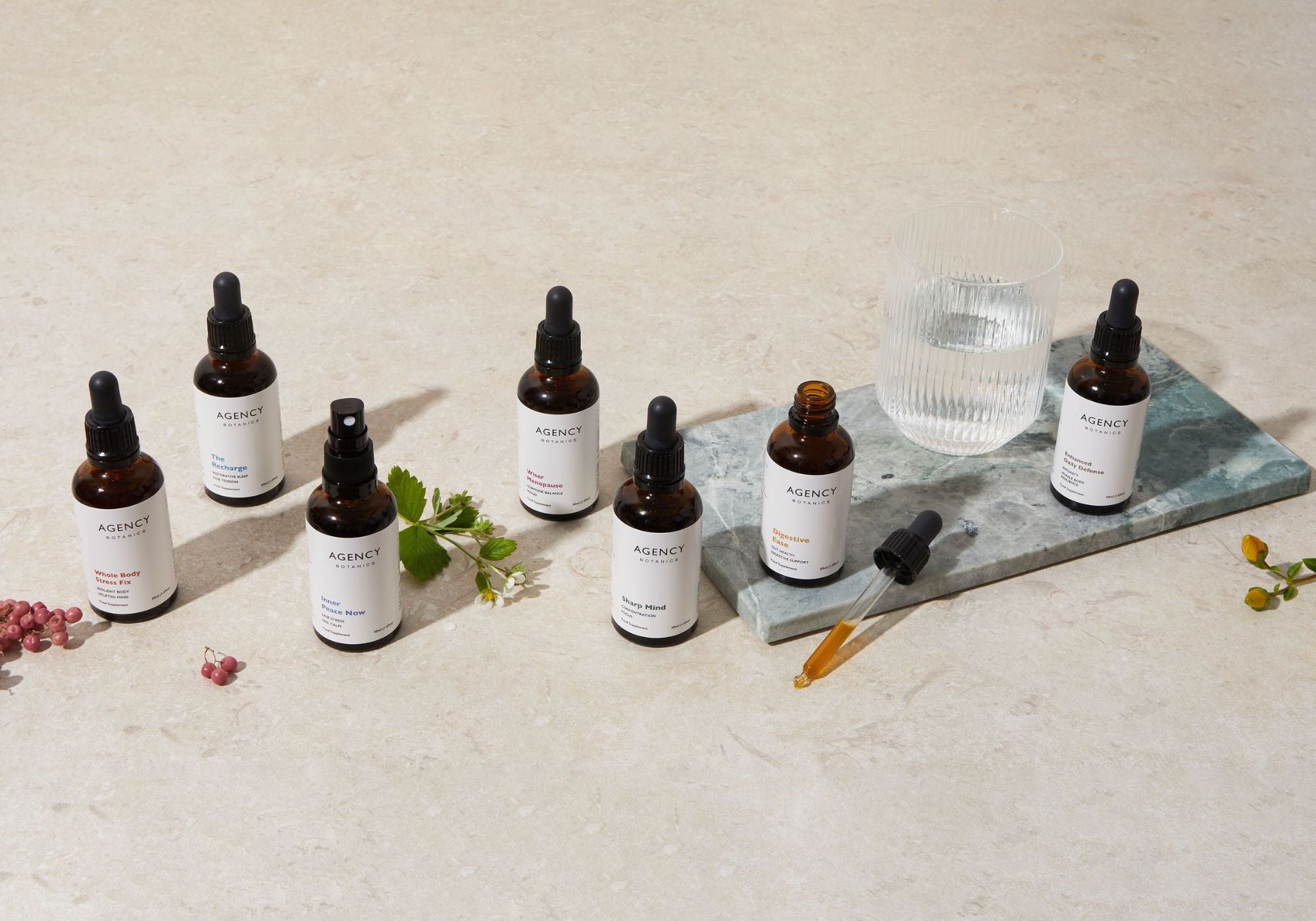 Assortment of organic herbal tinctures and supplements from Agency Botanics for stress (adaptogens), gut health (oregon grape root), immunity (astragalus), menopause (vitex), brain health (Lion's Mane), sleep (passionflower).
